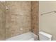 This bathroom features tiled walls, a bathtub, modern fixtures, and neutral coloring at 5293 Aldeburgh Dr, Suwanee, GA 30024