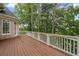 A spacious wooden deck offers a place to relax amidst lush greenery and tall trees at 5293 Aldeburgh Dr, Suwanee, GA 30024
