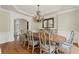 A dining room featuring a chandelier, lots of trim, an inlaid table, and hardwood floors at 5293 Aldeburgh Dr, Suwanee, GA 30024