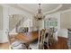 An open dining room featuring a chandelier, trim, and hardwood floors at 5293 Aldeburgh Dr, Suwanee, GA 30024