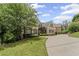 Elegant brick home showcasing its well-manicured lawn, mature trees and extended driveway at 5293 Aldeburgh Dr, Suwanee, GA 30024