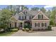 Stunning brick home featuring manicured landscaping, dark shutters, and a spacious driveway at 5293 Aldeburgh Dr, Suwanee, GA 30024