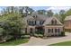 Charming brick home featuring a meticulously landscaped front yard, driveway, and a well-maintained lawn at 5293 Aldeburgh Dr, Suwanee, GA 30024