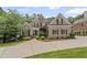 Classic brick home with lush landscaping, dark shutters, and a spacious driveway for easy access at 5293 Aldeburgh Dr, Suwanee, GA 30024