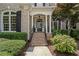 Charming front entryway with brick steps, white columns, and lush, professionally maintained landscaping at 5293 Aldeburgh Dr, Suwanee, GA 30024