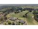 Aerial view showcasing the golf course with lush green fairways, sand traps, and surrounding trees and neighborhood at 5293 Aldeburgh Dr, Suwanee, GA 30024