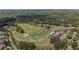 Overhead view features a golf course with sand traps, putting greens and surrounding neighborhood at 5293 Aldeburgh Dr, Suwanee, GA 30024