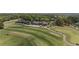 Aerial photo highlighting the meticulously designed golf course alongside a clubhouse and well-maintained green fairways at 5293 Aldeburgh Dr, Suwanee, GA 30024