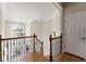 Second floor hallway featuring wood floors, iron railing, overhead lighting and view of foyer at 5293 Aldeburgh Dr, Suwanee, GA 30024