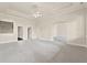 Open living room with neutral paint, plush carpeting, and arched doorway, creating an inviting atmosphere at 5293 Aldeburgh Dr, Suwanee, GA 30024