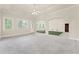 Spacious living room with neutral tones, carpet flooring, and access to an indoor putting green at 5293 Aldeburgh Dr, Suwanee, GA 30024