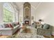 Bright living room showcasing large windows, a stone fireplace, and comfortable seating at 5293 Aldeburgh Dr, Suwanee, GA 30024