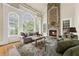 Living room filled with natural light from large windows and a stone fireplace focal point at 5293 Aldeburgh Dr, Suwanee, GA 30024