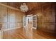 A spacious office featuring wood paneling, hardwood floors, and elegant lighting at 5293 Aldeburgh Dr, Suwanee, GA 30024
