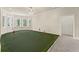 Features an indoor putting green with flags and multiple windows for ample natural light at 5293 Aldeburgh Dr, Suwanee, GA 30024
