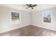 A bedroom with hardwood floors and a ceiling fan, illuminated by natural light from two windows at 2260 Old Spring Se Rd, Smyrna, GA 30080