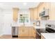 Modern kitchen with stainless steel appliances, white countertops, light wood cabinets, and herringbone backsplash, offering a stylish cooking space at 2260 Old Spring Se Rd, Smyrna, GA 30080
