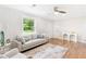 Bright living room with neutral-toned walls, wood floors, and comfortable seating, illuminated by natural light from a nearby window at 2260 Old Spring Se Rd, Smyrna, GA 30080