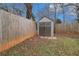 Backyard storage shed bordered by a wooden fence and healthy lawn at 2308 Scotty Cir, Decatur, GA 30032