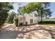 Back exterior with a large concrete parking area and lots of mature shade trees at 26 Kensington Rd, Avondale Estates, GA 30002