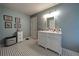 A well-lit bathroom featuring black and white patterned flooring, a white vanity, and framed prints at 26 Kensington Rd, Avondale Estates, GA 30002