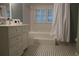 Light and airy bathroom featuring black and white patterned floors, white vanity, shower, and tub at 26 Kensington Rd, Avondale Estates, GA 30002