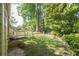 Lush backyard with mature trees, a small deck, and partial fencing at 2825 Harbor Cove Ct, Cumming, GA 30041