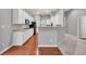 Open kitchen floorplan boasts white cabinetry, hardwood floors, stainless appliances and peninsula bar seating at 2825 Harbor Cove Ct, Cumming, GA 30041