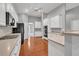 Well-lit kitchen featuring white cabinetry, hardwood flooring, stainless appliances, and bar seating at 2825 Harbor Cove Ct, Cumming, GA 30041