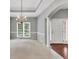Spacious living room with tray ceilings, chandelier lighting, large windows, and hardwood entry at 2825 Harbor Cove Ct, Cumming, GA 30041