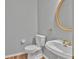 Cozy powder room featuring a pedestal sink, gold fixtures, and a round mirror at 2825 Harbor Cove Ct, Cumming, GA 30041