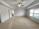 Spacious bedroom featuring neutral carpeting, fan and plenty of space at 4449 Sierra Creek Dr, Hoschton, GA 30548
