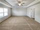Large bedroom featuring neutral carpeting, fan and plenty of space at 4449 Sierra Creek Dr, Hoschton, GA 30548