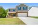 Charming two-story home with a well-manicured lawn and attached two-car garage at 6900 Oak Valley Dr, Douglasville, GA 30134