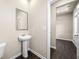 Cozy powder room with a pedestal sink and a large mirror, adjacent to hallway at 6900 Oak Valley Dr, Douglasville, GA 30134