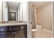 Bathroom with a granite countertop, dark cabinets, and a shower-tub combo with tiled walls at 11760 Stratham Dr, Alpharetta, GA 30009