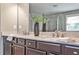 Bathroom featuring double vanity with dark cabinets, granite countertops and a large mirror at 11760 Stratham Dr, Alpharetta, GA 30009