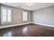 Spacious bedroom with hardwood floors, white shutters, and a decorative ceiling light at 11760 Stratham Dr, Alpharetta, GA 30009