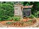 Welcoming community entrance with stone signage amidst landscaped greenery and flowers at 11760 Stratham Dr, Alpharetta, GA 30009