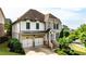 Charming two-story home featuring a brick and white siding facade, two-car garage and well-manicured landscaping at 11760 Stratham Dr, Alpharetta, GA 30009
