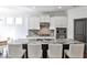 Well-lit kitchen features white cabinets, gray backsplash, and expansive island at 11760 Stratham Dr, Alpharetta, GA 30009