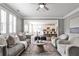Cozy living room with neutral tones, ceiling fan, and open view to kitchen at 11760 Stratham Dr, Alpharetta, GA 30009