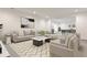 Modern living room featuring neutral tones, stylish decor, and an open layout leading to a game room at 11760 Stratham Dr, Alpharetta, GA 30009