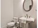 Elegant powder room with pedestal sink, oval mirror, and classic design at 11760 Stratham Dr, Alpharetta, GA 30009