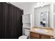 Well-lit bathroom featuring a shower with decorative curtain, vanity, and convenient storage at 632 Plaza Se Dr # 6, Kennesaw, GA 30144