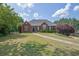 Charming one-story brick home boasts a well-manicured lawn and mature trees, offering great curb appeal at 6455 Crystal Ln, Cumming, GA 30040