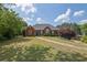 Charming one-story brick home boasts a well-manicured lawn and mature trees, offering great curb appeal at 6455 Crystal Ln, Cumming, GA 30040