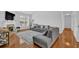 Bright living room featuring hardwood floors, a stylish gray sofa, fireplace, and large window, offering a comfortable space at 6455 Crystal Ln, Cumming, GA 30040