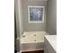 Bathroom features a bathtub with white tile surround and a window at 7245 W Strickland St, Douglasville, GA 30134