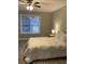 Bedroom with neutral walls and flooring, ceiling fan and a bright window at 7245 W Strickland St, Douglasville, GA 30134